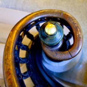 A spiral at the end of a wooden bannister. Staircase.